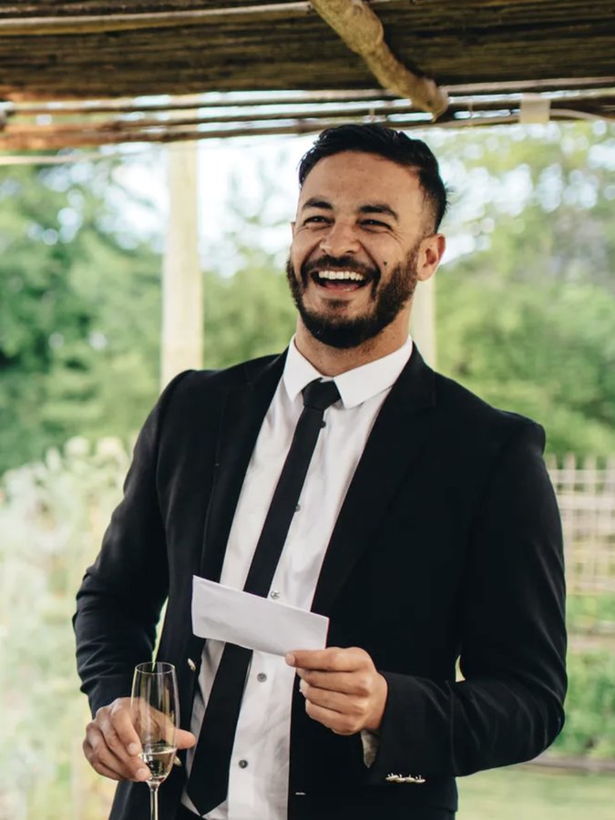 Caballero con traje negro, camisa blanca y corbata